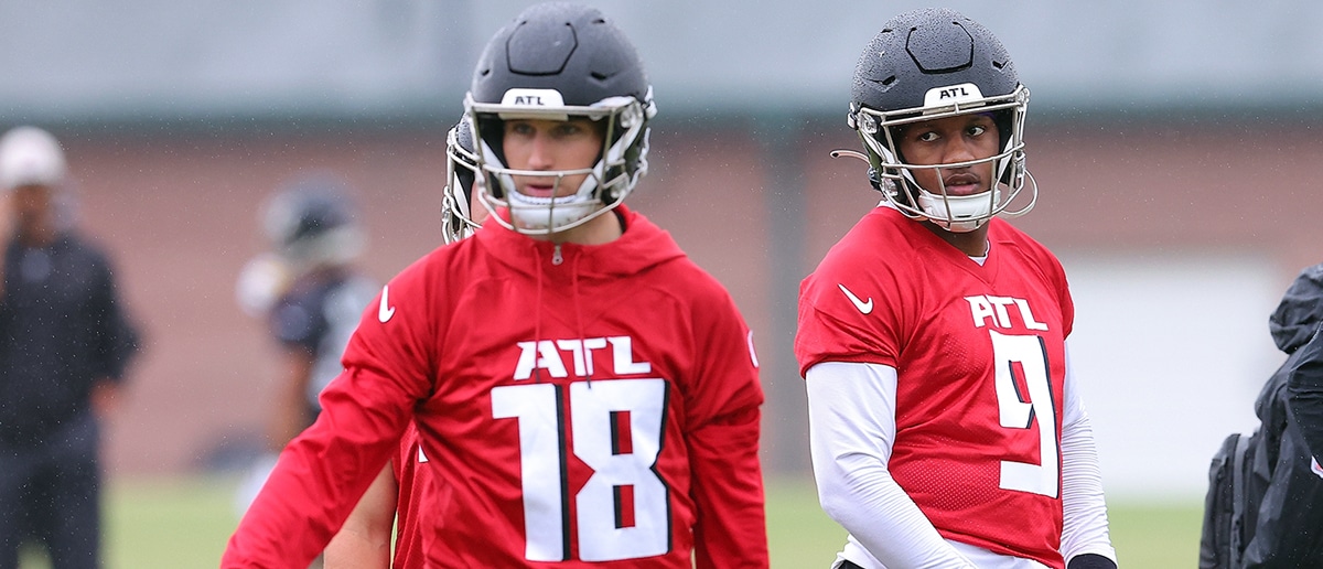 Quarterback Michael Penix Jr. #9 of the Atlanta Falcons looks on behind quarterback Kirk Cousins #18 during OTA offseason workouts at the Atlanta Falcons training facility on May 14, 2024 in Flowery Branch, Georgia.