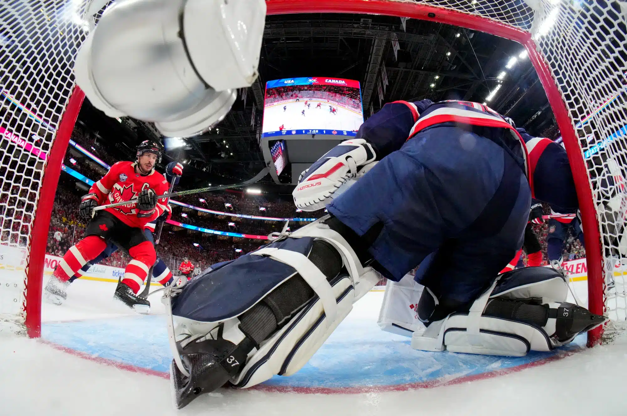 Connor Hellebuyck #37 of Team United States makes a save as Sidney Crosby #87 of Team Canada looks for the rebound during the second period of the 4 Nations Face-Off game between the United States and Canada at Bell Centre on February 15, 2025 in Montreal, Quebec. Team USA leads with the best 4 Nations betting odds.