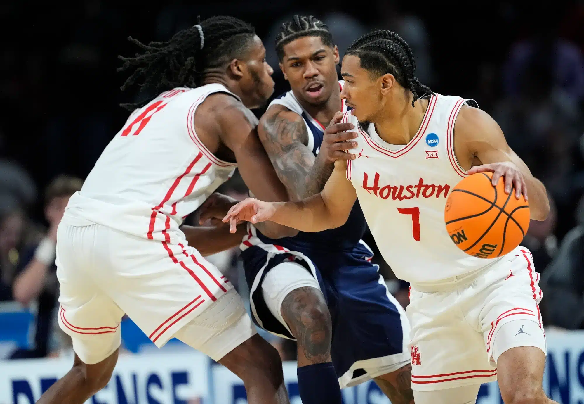 Milos Uzan #7 of the Houston Cougars dribbles the ball as Joseph Tugler #11 sets a pick on Khalif Battle #99 of the Gonzaga Bulldogs during the first half in the second round of the NCAA Men's Basketball Tournament at INTRUST Arena on March 22, 2025 in Wichita, Kansas.