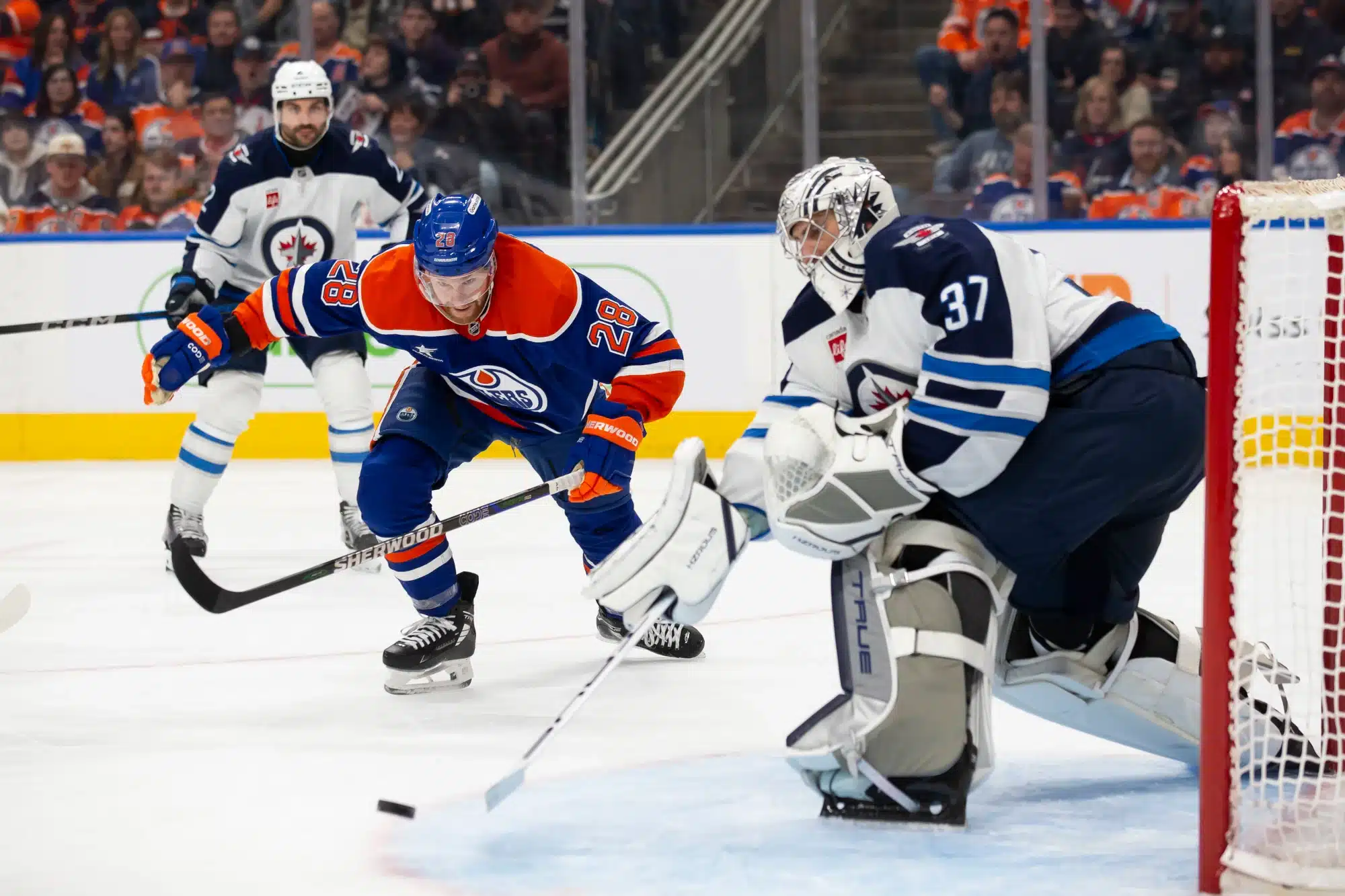 Connor Brown #28 of the Edmonton Oilers skates against goaltender Connor Hellebuyck #37 of the Winnipeg Jets during the second period at Rogers Place on March 20, 2025 in Edmonton, Canada.