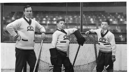 A picture of Art Ross on the ice with his sons.