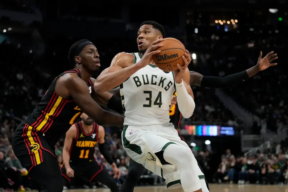 Giannis Antetokounmpo #34 of the Milwaukee Bucks dribbles the ball against Onyeka Okongwu #17 of the Atlanta Hawks during the first quarter at Fiserv Forum on March 30, 2025 in Milwaukee, Wisconsin.