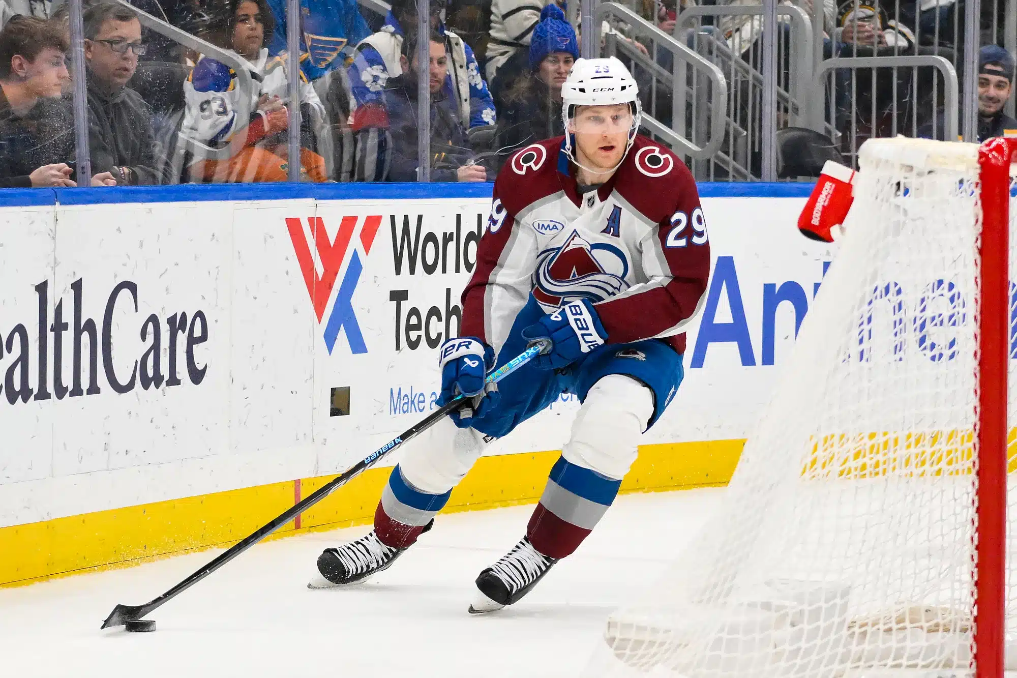 Nathan MacKinnon #29 of the Colorado Avalanche skates with the puck behind the net at an NHL game in April 2025.
