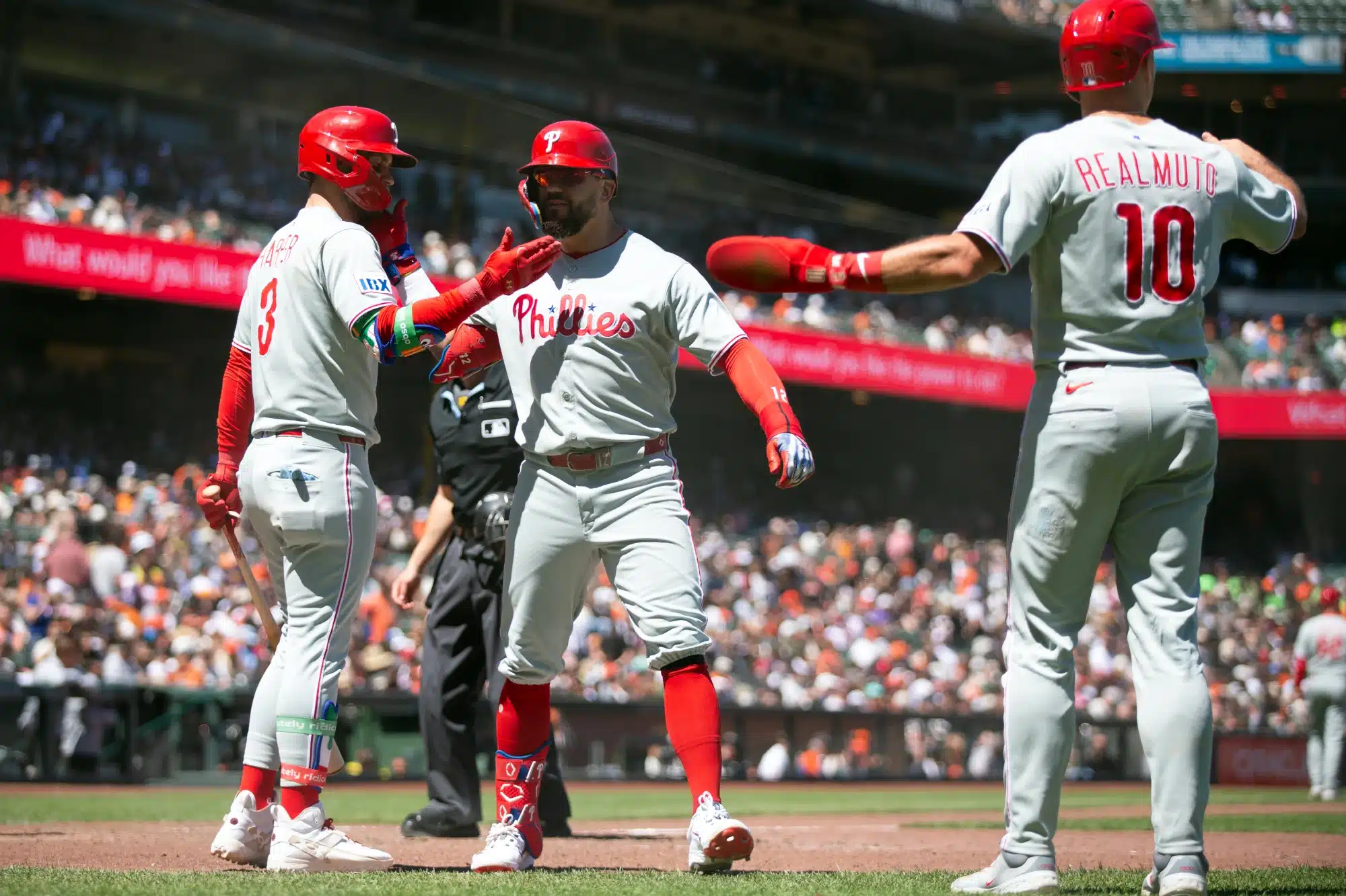 Jul 9, 2025; San Francisco, California, USA; Philadelphia Phillies designated hitter Kyle Schwarber (center) is greeted by teammates Bryce Harper (3) and J.T. Realmuto (10) after hitting a three-run home run against the San Francisco Giants during the eighth inning at Oracle Park. 