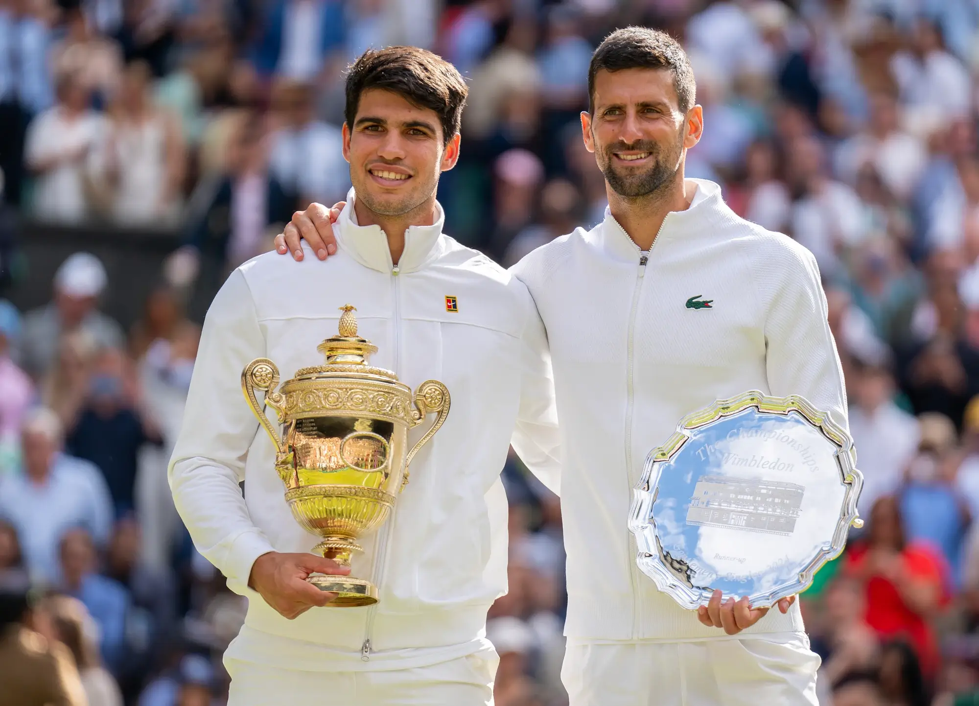 2024 Wimbeldon champion Carlos Alcaraz of Spain stands next to Wimbledon runner-up Novak Djokovic of Serbia in the trophy ceremony at centre court.